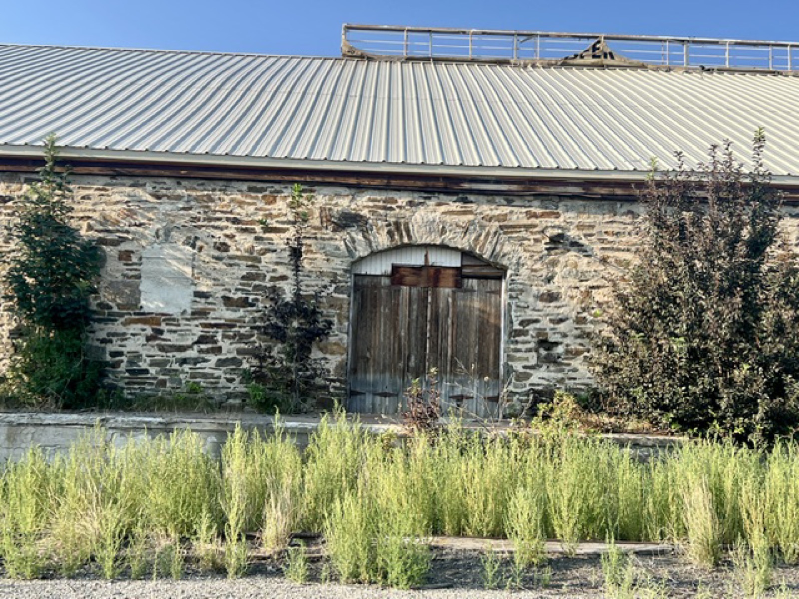 Rear stone wall with arched wooden barn doors