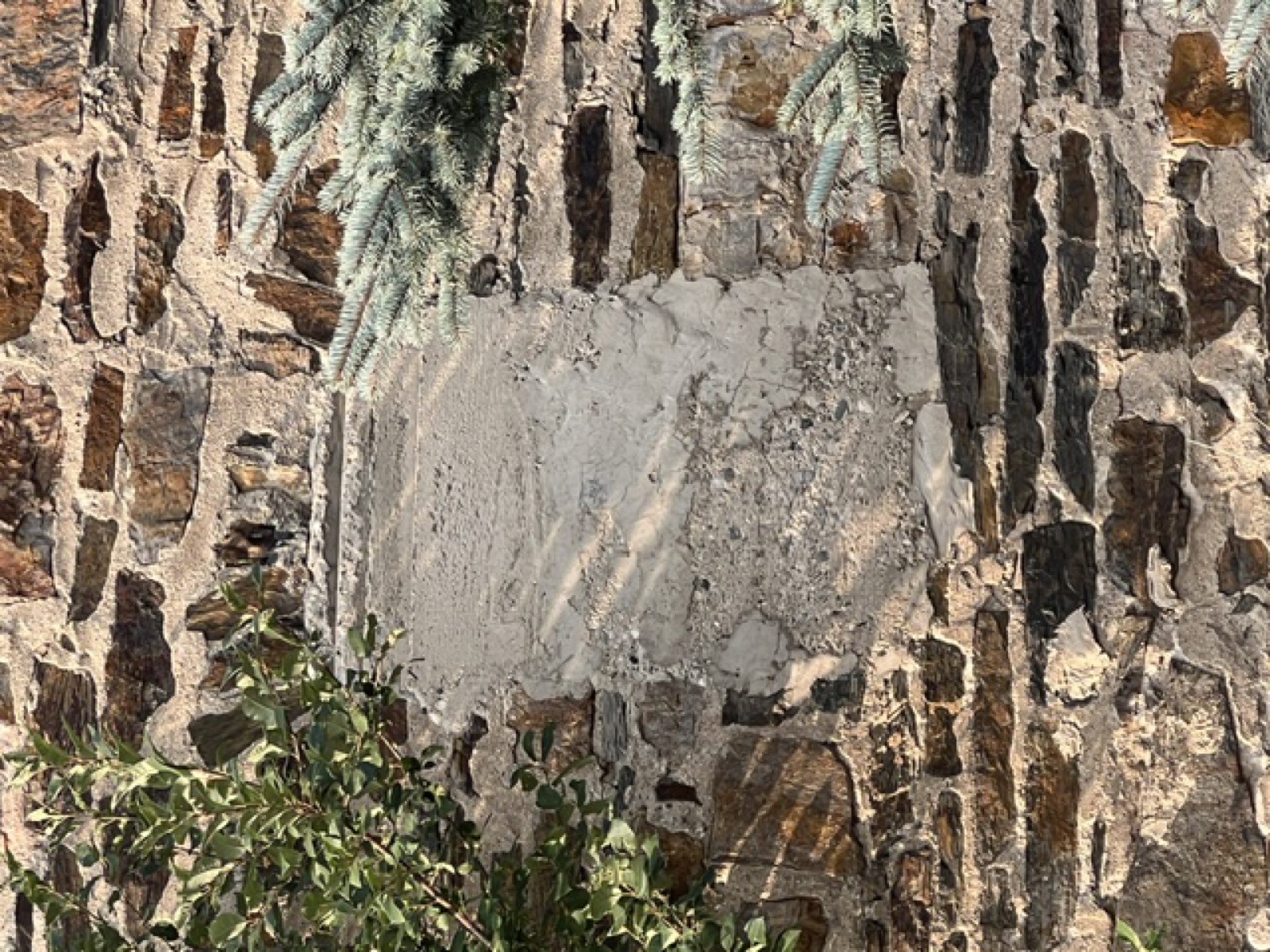 A rectangular cement patch in the stone wall