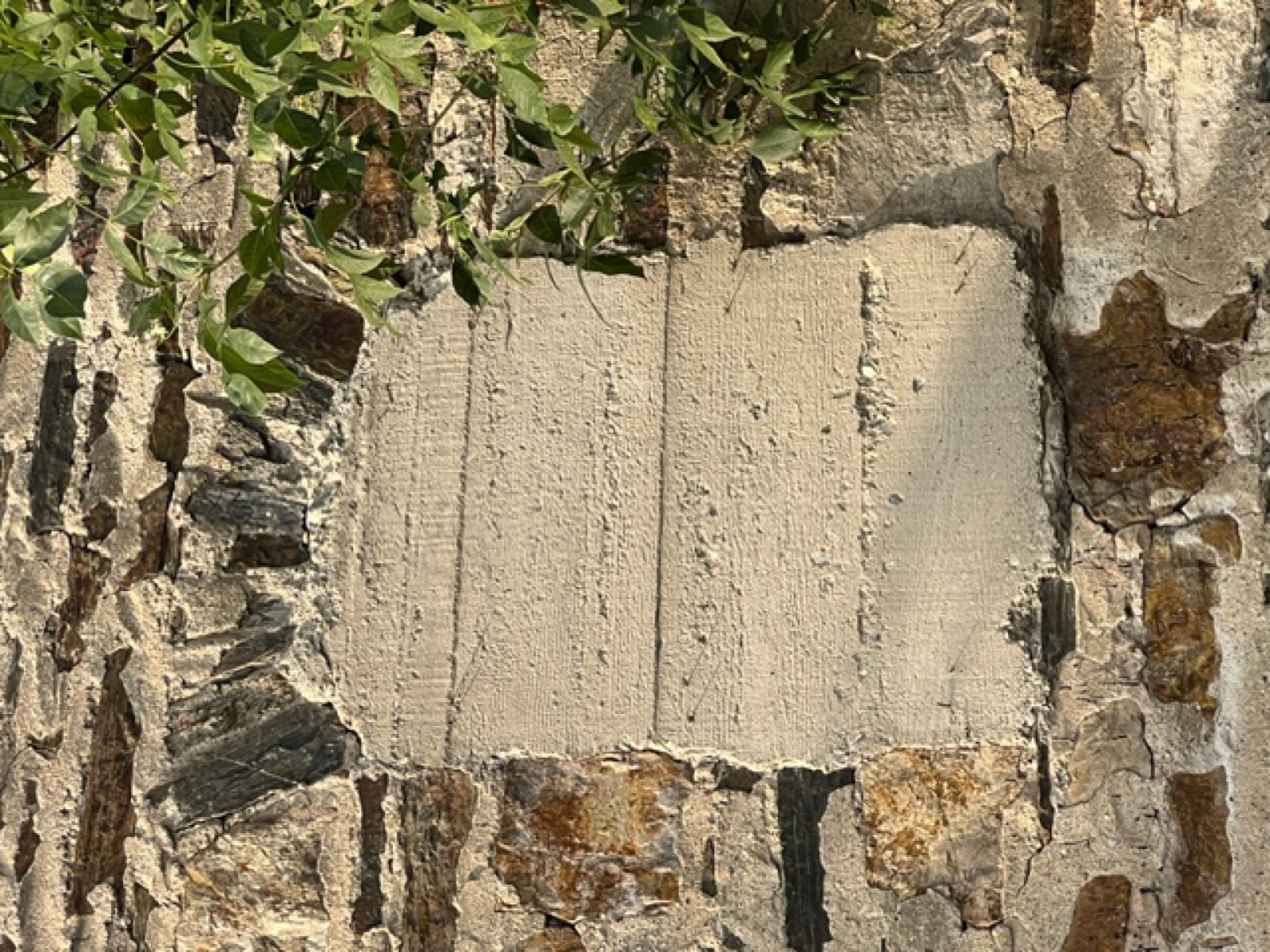 A vertical infilled opening in the stone, tool-smoothed